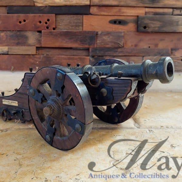 Small vintage replica Spanish cannon on wooden carriage with plaque stating "Artilleria Imperial Carlos I"